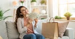 Woman holding cash and shopping bags showing how to save $500 fast without sacrificing fun